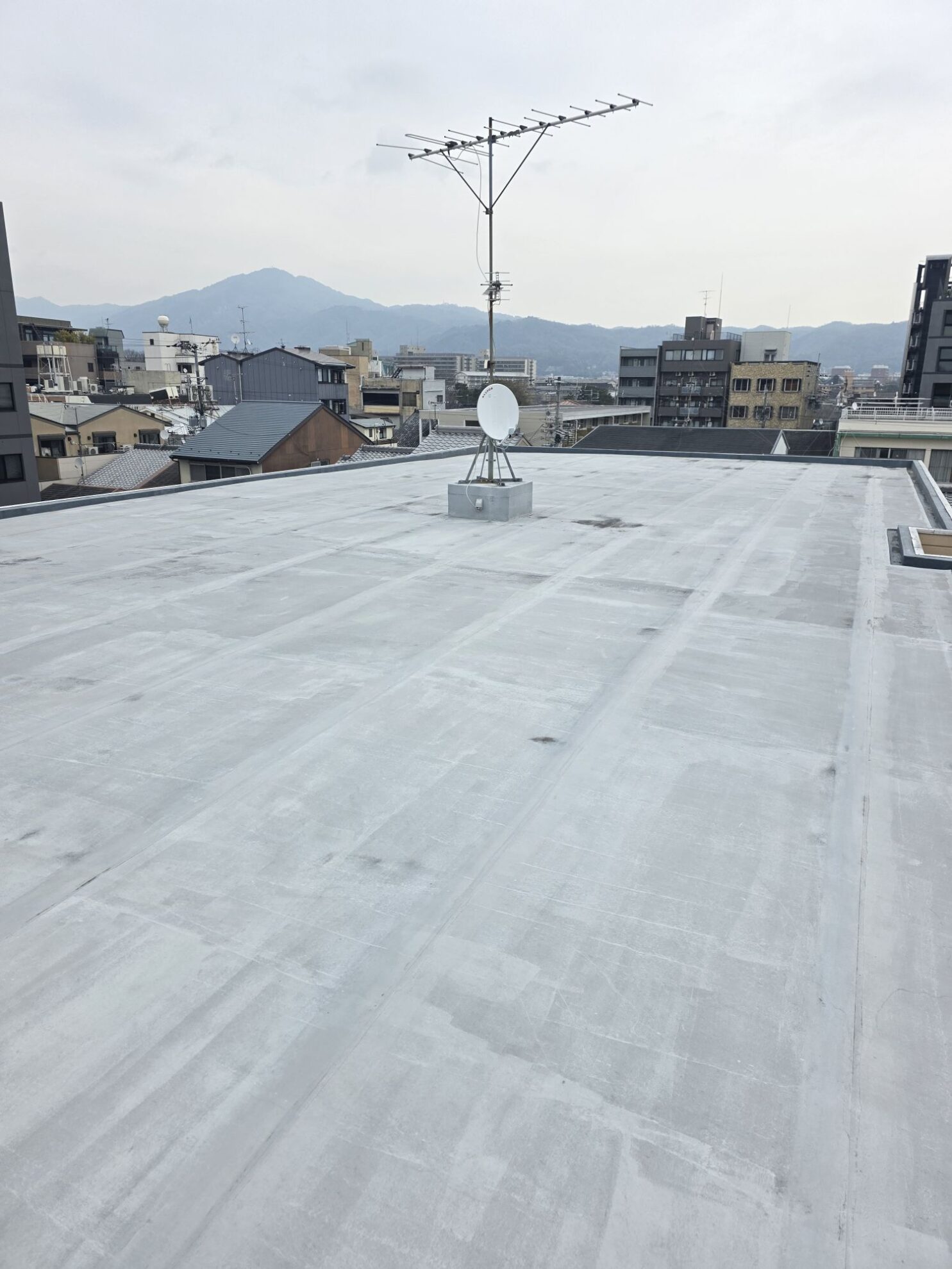 マンション屋上全体の防水層が経年劣化している状態を上から撮影した現場写真